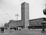 Der weitgehend fertiggestellte Südflügel des neuen Düsseldorfer Hauptbahnhofs mit dem hochragenden Uhrenturm, der in seiner Ausführung an den Bonatz-Bau des Stuttgarter Hauptbahnhofs erinnert. Dort, wo Eingangshalle und Nordflügel entstehen werden, nimmt noch das alte Empfangsgebäude den Platz ein. (09.11.1932) <i>Foto: RBD Wuppertal (Eckler)</i>