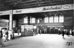 In der ersten Zeit nach dem Zweiten Weltkrieg war in der Halle des Düsseldorfer Hauptbahnhofs mit seinem provisorisch eingezogenen Notdach vom Glanz und der Weitläufigkeit früherer Tage nichts mehr zu sehen. Bescheide Lichtblicke in der Trostlosigkeit waren die wenigen Verkaufsbuden und die unvermeitliche Werbung eines ortsansässigen Waschmittelherstellers. (1951) <i>Foto: Walter Eckler</i>