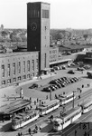 Blick aus dem Goethe-Institut über den heutigen Konrad-Adenauer-Platz auf den frisch renovierten Düsseldorfer Hauptbahnhof. Der alles überragende Teil des Empfangsgebäudes, der weithin sichtbar verkündet, was die Stunde geschlagen hat, erfüllte auch die Funktion eines Wasserturms für die Versorgung der Dampflokomotiven. (1957) <i>Foto: Ernst Winter</i>