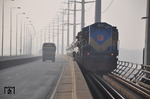 Ein Bild von der Breitspur (1676mm): Der Fluß Jamuna trennt die Eisenbahnnetze von Bangladesch und Indien, die aber dank der Jamuna-Bridge und der Doppelspurgleise miteinander verbunden sind. Hier überquert die in Indien gebaute Breitspurlok BR 6511 die Schiene/Straße-Brücke in Richtung Dhaka.  (12.01.2015) <i>Foto: Johannes Glöckner</i>