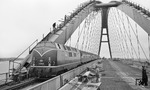 Die 963 Meter lange Fehmarnsundbrücke überspannt den 1300 Meter breiten Fehmarnsund, wobei die restlichen 337 Meter aus beidseitigen Rampen bestehen. Nach gut drei Jahren Bauzeit wurde die Brücke am 30. April 1963 eingeweiht. Die erstmalige Nutzung erfolgte ab 16. Januar 1963, dazu gehörten Versuchsfahrten mit der hier gezeigten V 200 111. (12.03.1963) <i>Foto: Walter Hollnagel</i>