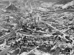 Luftaufnahme von Oker im Harz, heute ein Stadtteil von Goslar, mit der Harzer Hüttentechnik (Bleihütte Oker, Zinkoxydhütte Oker und Zinkhütte Harlingerode) sowie links der Bahnstrecke Goslar - Bad Harzburg. (1955) <i>Foto: Hansa-Luftbild</i>