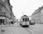 Auf der Bahnhofstraße überholt ein Büssing-Bahnbus einen Zug der Linie 1 nach Sennelager. Links das heute nicht mehr bestehende Modehaus Olk an der Ecke Borchener Straße, rechts das Zollamt.  (08.02.1962) <i>Foto: Reinhard Todt</i>