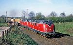 220 048 + 220 025 passieren mit KLV-Zug Ne 62672 den Bahnübergang "Im Seybeck" in Rümpel, südlich von Bad Oldesloe. (18.04.1981) <i>Foto: Joachim Bügel</i>