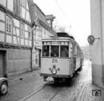 Durch die Mühlenenge in Schloß Neuhaus zwängte sich sowohl die Straßenbahnlinie 1 der PESAG als auch – bis zum Bau der Neuhäuser Umgehungsstraße – die Bundesstraße B 68. Hier ist der Tw 29 in Richtung Paderborn unterwegs. Neben den Brems- und Schlußleuchten hatte er in den 1950er Jahren auch aufgesetzte Liniennummernschilder erhalten, die allerdings nie genutzt wurden.  (1958) <i>Foto: Reinhard Todt</i>