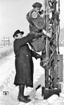 Ein deutscher Eisenbahner mit einem französischen Kriegsgefangenen bei der Wartung der Signallaternen an einem Ausfahrsignal im Bahnhof Jünkerath. (01.1945) <i>Foto: Walter Hollnagel</i>
