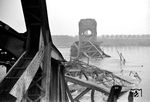 Die Kölner Südbrücke wurde - im Gegensatz zur Hohenzollernbrücke - nicht durch die deutsche Wehrmacht gesprengt, sondern am 6. Januar 1945 durch alliierte Bomben weitgehend zerstört. Der im Strom liegende Mittelbogen musste nach dem Krieg weggesprengt werden und stand für den Wiederaufbau deshalb nicht mehr zur Verfügung. Im Mai 1946 wurde die Brücke zunächst provisorisch und eingleisig wieder freigegeben, später für 10 Millionen DM neu errichtet und am 1. Oktober 1950 wieder in Betrieb genommen.  (02.1945) <i>Foto: Walter Hollnagel</i>