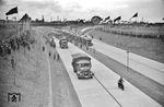 Eine lange Schlange von Reichsbahn-Lkw macht sich in Opladen bereit, die neu eröffnete Reichsautobahn nach Düsseldorf zu befahren. Wenigstens bei der Eröffnung sollte es nach viel Betrieb aussehen, steckte der Individualverkehr doch noch in den Kinderschuhen, der KdF-Wagen (VW-Käfer) sollte er ab 1940 produziert werden.   (21.05.1936) <i>Foto: Theo Felten</i>