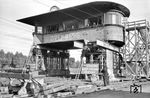 Anhebung des Stellwerks "Gn" im Rangierbahnhof Gremberg anlässlich der Elektrifizierungsarbeiten auf der rechten Rheinstrecke. Auch 17 Jahre nach Kriegsende sind die Einschusslöcher in der Fassade nicht verschwunden. (1962) <i>Foto: Fischer</i>