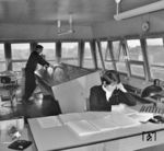 Blick in das am 01. September 1969 neu eröffnete GS II DR-Stellwerk von Rostock Hbf mit dem Fahrdienstleiter am Bedienpult und der Zugmelderin im Vordergrund. (03.12.1969) <i>Foto: Historische Sammlung der Deutschen Bahn AG</i>