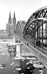 Blick von dem südlichen Deutzer Brückenturm auf eine über die Hohenzollernbrücke rollende 03. Für Kölner Verhältnisse muss es ein kalter Winter gewesen sein, selbst auf dem Rhein treiben Eisschollen - heute wohl eine Sensation. (02.1953) <i>Foto: Fischer</i>