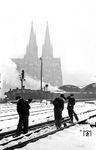 Auch in Köln liegt tatsächlich ab und zu Schnee: Hilfreiche Hände befreien die Weichen im Kölner Hauptbahnhof von der weißen Pracht. Vor dem Dom dampfen eine "entstromte" 01.10 und eine P8. (1951) <i>Foto: Fischer</i>