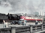 Lebhafter Verkehr auf Straße und Schiene auf der Lombardsbrücke in Hamburg: Ein VT 11 aus Altona kreuzt einen Güterzug mit der Harburger 93 982. (04.1960) <i>Foto: Walter Hollnagel</i>