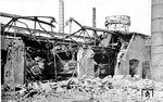 Eine nicht identifizierte Güterzuglok im zerstörten Schuppen des Bw Osnabrück. Auch den markanten Wasserturm hat es voll erwischt. (14.09.1944) <i>Foto: RBD Münster</i>