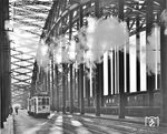 Bis zur Sprengung der Kölner Hohenzollernbrücke am 06. März 1945 wurde die Rheinbrücke parallel von Straßen- und Schienenfahrzeugen benutzt. Hier überquert Wagen 837 der Kölner Verkehrs-Betriebe (KVB) als Linie 19 zum Rheinpark die Brücke in Richtung Deutz.  (1932) <i>Foto: RBD Köln (Felten)</i>