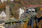 Über die Wupperbrücke in Wuppertal-Sonnborn rollt eine 111 mit RE 10414 (Dortmund - Aachen), während unten Wuppertals Wahrzeichen vorbeischwebt. (03.11.2015) <i>Foto: Wolfgang Bügel</i>