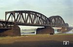 Die 1912 erbaute Haus-Knipp-Eisenbahnbrücke über den Rhein nördlich der Duisburg-Ruhrorter Häfen zwischen Duisburg-Beeckerwerth und Duisburg-Baerl im Verlauf der Bahnstrecke Oberhausen – Moers. (27.11.1984) <i>Foto: Peter Schiffer</i>