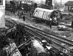 Am Abzweig Blankenheim, südlich von Bebra, ereignete sich am 22. Januar 1954 dieser Unfall des Dg 7292, bei dem zwei Menschen starben. Der von Bebra nach Würzburg fahrende Güterzug Dg 7292 prallte gegen 0.25 Uhr mit einer Geschwindigkeit von 50-60 km/h auf einen Wagen des entgegenkommenden Dg 7369, der sich wegen eines Achsschenkelbruchs quergestellt und in den Fahrweg des Dg 7292 hineinragte. Lok und Tender des Dg 7292 kippten um, dabei kamen der 49-jährige Oberlokheizer Johannes Köhler aus Bosserode und der 46-jährige Zugführer Friedrich Böhm aus Nürnberg, der sich im Güterzugbegleitwagen aufhielt, ums Leben. Wie durch ein Wunder wurde der 47-jährige Lokführer Johannes Soldan aus Weiterode nur leicht verletzt. Auf dem Foto erkennt man die verunfallte und wieder auf den Gleisen stehende 50er des Dg 7292 (links), sowie ihren aufgerichteten Tender am Haken des 60t-Krans und dazwischen den Hilfszug mit einer Bebraer 41er. (22.01.1954) <i>Foto: Helmut Först</i>