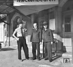 Zufriedene Eisenbahner in Meckenbeuren an der württembergischen Südbahn Ulm – Friedrichshafen. Es präsentieren sich wohl der Aufsichtsbeamte, der Mann in der Fahrkartenausgabe sowie der Bahnhofslehrling dem Fotografen. (30.05.1959) <i>Foto: Joachim Claus</i>