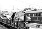 Im Jahre 1956 startete die DB das 1930 als "Auto-Gepäck-Verkehr" von der Deutschen Reichsbahn eingeführte Konzept des Autoreisezuges neu. Zunächst erfolgte die Beförderung in geschlossenen umgebauten Gepäckwagen, später auf den neuen Offs60 Wagen (ganz links), die hier dem DB-Fotografen vorgestellt wurden. Als Auffahrwagen an der Verladerampe dient ein SS15-Wagen (DVW A3). Bis 1973 wurde die Zahl der Autozugrelationen auf 163 Verbindungen gesteigert. Heute dümpelt der seit 1996 unter der Bezeichnung "Autozug" betriebene Verkehr eher vor sich hin. Das Bild entstand wohl auf der Autoverladeanlage in Kornwestheim Pbf. (1960) <i>Foto: Willi Doh</i>