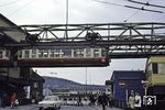 Ein Schwebebahnwagen verlässt die Wendescheife in Wuppertal-Oberbarmen und fährt in die gleichnamige Station ein. Im Hintergrund ist das Empfangsgebäude des alten Bahnhofs Oberbarmen zu erkennen.  (22.06.1970) <i>Foto: Robin Fell</i>