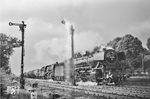 Mit einem Kesselwagenzug rauschen 41 304 (Bw Osnabrück Hbf) und 50 1806 (Bw Osnabrück Vbf) durch den Bahnhof Bohmte. Leider ist das Negativ durch einen Lichteinfall beschädigt. (16.05.1961) <i>Foto: Joachim Claus</i>