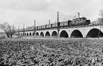 DR 254 110 (ex E 94 110, AEG, Baujahr 1943) mit einem Braunkohle-Ganzzug auf dem Leipziger Güterring über die Elsteraue bei Leipzig-Wiederitzsch. Der Viadukt gehört mit 565 m zu den längsten Eisenbahnbrücken in Sachsen.  (03.1988) <i>Foto: Michael Malke</i>