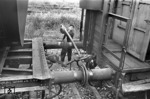 Im Rangierbahnhof Gremberg werden von einem „Entkuppler“ mit Hilfe einer Kuppelstange während der langsamen Vorbeifahrt in Richtung Ablaufberg die Güterwagen von der Seite her entkuppelt. (1955) <i>Foto: Fischer</i>