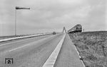 V 200 112 hat soeben die Fehmarnsundbrücke hinter sich gelassen und betritt bei Großenbrode das Festland, wo neben der Bundesstraße 207 vor Seitenwind gewarnt wird.  (09.1965) <i>Foto: Reinhard Todt</i>
