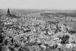 Die Stadt Köln wurde im Laufe des 2. Weltkriegs 262 mal bombardiert, mehr als jede andere deutsche Stadt. Mit der "Operation Millennium" war Köln in der Nacht vom 30. auf den 31. Mai 1942, Ziel der Royal Air Force (RAF), die hier erstmals über 1000 Bomber gleichzeitig einsetzte. Rund 20.000 Kölner starben durch die Luftangriffe. Der verheerendste Angriff erfolgte in der Nacht auf den 29. Juni 1943, bei dem etwa 4300 Menschen starben und rund 230.000 obdachlos wurden. Am 2. März 1945 griff die RAF Köln zum letzten Mal mit 858 Bombern in zwei Phasen an. Im Rahmen der "Operation Lumberjack" wurde wenige Tage später der linksrheinische Teil Kölns von der 1. US-Armee eingenommen, am Abend des 6. März 1945 war der Krieg in Köln beendet. Der deutsche Rundfunk meldete hierzu: "Der Trümmerhaufen Köln wurde dem Feinde überlassen." Im Frühjahr 1945 lebten nur noch 40.000 Menschen in Köln; vor dem Krieg waren es 768.000. Rechts vom Dom liegt die (von den Deutschen) gesprengte Hohenzollernbrücke im Rhein, darunter die Deutzer Brücke. (24.04.1945) <i>Foto: Pressefoto ACME</i>