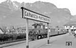 Zur Betriebseröffnung der bayerischen Zugspitzbahn wurden 1930 von der AEG zwölf Lokomotiven geliefert. Darunter vier Tallokomotiven für den Adhäsionsabschnitt mit den Betriebsnummern 1 bis 4, sowie acht Berglokomotiven für den Zahnstangenabschnitt mit den Betriebsnummern 11 bis 18. Die zweiachsigen Tallokomotiven - hier Lok 2 mit den Wagen 1, 7, 14 und 15 im Bahnhof Garmisch - mit der Achsfolge Bo und ihrer Leistung von 2 x 112 kW erreichten maximal 50 km/h. Mit den lokbespannten Zügen konnten die Fahrgäste die gesamte Strecke erstmalig ohne Umstieg zurücklegen. (05.03.1959) <i>Foto: Gerd Wolff</i>