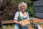 Im Kostüm des "Ötscherbären" verbirgt sich Renate Wachauer, die neben dem Werbemaskottchen hier im Dirndl auch die einheimischen "Wuchteln" präsentiert - süße, teils gefüllte Germknödel, die im Ofen gebacken werden. (21.07.2017) <i>Foto: Joachim Schmidt</i>