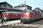 Während 220 005-3 vor E 2656 (Würzburg - Pirmasens) auf den Abfahrauftrag des Aufsichtsbeamten wartet, bringt der Zugführer des E 3511 (Lauda - Ulm) den Bremszettel zur 215 004-3. (27.04.1975) <i>Foto: Peter Schiffer</i>