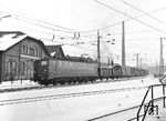 150 033 (Bw Würzburg) fährt mit einem Güterzug in Aschaffenburg ein. Im Hintergrund das heute völlig verfallene Bahnbetriebswerk. (02.01.1971) <i>Foto: Joachim Claus</i>