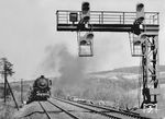 Am 8. Ok­to­ber 1951 wurde das Berggleis von Bebra nach Corn­berg als erster Abschnitt mit Gleiswechselbetrieb (GWB) auf einer DB-Strecke in Betrieb genommen. Hier waren Stei­gun­gen bis 1:77 und kleinste Halbmesser von 300 Me­tern zu durch­fah­ren, um von Bebra bis zum Cornberger Tunnel auf 12 km einen Hö­hen­un­ter­schied von 108 Me­tern zu überwinden. Güterzüge benötigten bis zu 30 Minuten für diesen Abschnitt. Mit dem GWB bestand die Möglichkeit, einen Güterzug und einen Personenzug gleich­zei­tig in Bebra aus­fahren zu lassen, den langsameren Güterzug auf dem linken Strec­kengleis, den schnelleren Personenzug auf dem rechten Streckengleis überholen zu lassen. An mehreren Stel­len auf der Strecke zwischen Bebra und Cornberg konnte der langsamere Gü­terzug wieder auf das rechte Gleis wechseln, wenn ihn der schnellere Per­sonenzug überholt hatte. Das Bild zeigt einen talwärtsfahrenden Güterzug mit der Bebraer 44 1254 an der Überleitstelle Mitte, während im Hintergrund eine anderer Güterzug gerade bergwärts kachelt. (1952) <i>Foto: Helmut Först</i>