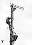 Wartungsarbeiten am mechanischen Einfahrsignal "G" eines Berliner Bahnhofs, welches bereits mit einem elektrischen Vorsichtssignal (Ve 6) ausgerüstet ist. Das "M" bedeutet, dass auf mündlichen Auftrag des Fahrdienstleiters am haltzeigenden Signal Hp 0 vorbeigefahren werden darf. (1942) <i>Foto: RVM (Ittenbach)</i>
