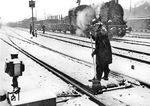 Das Auftauen und Reinigen der Weichen im Winter war und ist eine Grundvoraussetzung für einen funktionierenden Eisenbahnbetrieb. Hier werden im ersten Kriegswinter die Weichen im Bahnhof Hamburg-Rothenburgsort vom Schnee befreit, während 94 1094 auf Ausfahrt wartet. (1940) <i>Foto: RVM (Hollnagel)</i>