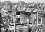 Blick in den heute verschwundenen Überseehafen von Bremen mit der "Jalaonarma" aus Bombay (Indien), die gerade von zwei Schleppern aus dem Hafen bugsiert wird. Oben links befindet sich die Weserwerft, in der Mitte die Getreideanlagen, rechts das Kühlhaus. (1959) <i>Foto: VV Bremen (Brockmöller)</i>