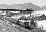 E 18 06 vom Bw München Hbf mit einem internationalen Schnellzug Richtung Traunstein bei Bergen in Oberbayern. Im Hintergrund verläuft die Bundesautobahn A 8. (1966) <i>Foto: Georg Steidl</i>