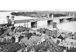 Die "Dombrücke" war die erste kombinierte Eisenbahn- und Straßenbrücke über den Rhein in Köln und die direkte Vorgängerin der heutigen Hohenzollernbrücke. Sie wurde ab 1855 gebaut und Anfang Oktober 1859 zusammen mit dem ersten Kölner „Centralbahnhof“ (in der Nähe des Eigelstein) auf der Maximinenstraße eröffnet. Mit der Eröffnung des neuen Hauptbahnhofs 1894 genügte die Dombrücke nicht mehr dem gewachsenen Verkehr und wurde durch die 1911 eröffnete Hohenzollernbrücke ersetzt. Das Bild vom Rathausturm offenbart den Blick über die im Zweiten Weltkriegs vollständig untergegangene (originale) Kölner Altstadt, während auf der Deutzer Seite noch die Messe fehlt. (1896) <i>Foto: RBD Köln</i>