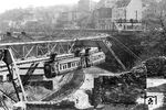 Trümmer beherrschen auch im Jahr 1954 das Bild in der Kluse in Wuppertal-Elberfeld. Ein Schwebebahnzug der Bauart B 00 passiert auf seinem Weg nach Oberbarmen die Stelle, an der sich von 1900 bis 1903 eine Umkehrschleife befunden hatte, bevor die Streckenverlängerung nach Barmen in Betrieb ging. Auch der hier im Krieg zerstörte Bahnhof "Kluse" wurde nicht wieder aufgebaut. Oben sieht man die bekannte Signalbrücke in der Osteinfahrt des Bahnhofs Wuppertal-Elberfeld. (03.1954) <i>Foto: Heinz Meyer, Slg. Wolfgang R. Reimann</i>