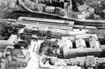 Blick von Norden auf die Wuppertaler Südstadt mit dem damaligen (noch) Hauptbahnhof von Elberfeld, der sich in die enge Tallage Wuppertals zwängen musste. Unter der Halle war nur Platz für vier Gleise und ein Überholungsgleis. Davor befindet sich das stattliche Gebäude der Eisenbahndirektion Elberfeld. (1928) <i>Foto: Hansa-Luftbild</i>