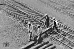 Einheimische Arbeitskräfte beim Transport umgenagelter Schwellen im Bahnhof Minsk. Deutlich sind im Bahnhof auch die von russischer Breitspur (1524 mm) auf das deutsche Maß (1435 mm) komplett umgenagelten Gleise und Weichen zu erkennen. Am 30. April 1942 meldeten die Reichsverkehrsdirektionen (RVD) im Osten 15.975 km umgespurter Gleise. Bei der größten erreichten Ausdehnung im Herbst 1942 betrieben rund 750.000 Betriebseisenbahner und einheimische Hilfskräfte mit 4.600 Lokomotiven ein Streckennetz von etwa 35.000 km in der besetzten Sowjetunion. Dies entsprach einem Drittel des sowjetischen Gesamtnetzes.  (1943) <i>Foto: RVM (Korte)</i>