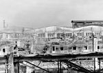 In der Nacht vom 9./10. März 1943 bombardierte die Royal Air Force (RAF) mit 600 t Brand- und Sprengbomben die Münchener Innenstadt. Hierbei wurde auch die E-Lokhalle des Bw München Hbf getroffen, die bis auf die Grundmauern niederbrannte. Hierbei brannten 16 E-Loks, drei Triebwagen, drei Steuerwagen und ein Beiwagen völlig aus. Das Bild zeigt den Mittelteil der ausgebrannten Halle mit E 18 09. Links steht E 18 23 mit einer E 44.  (11.03.1943) <i>Foto: RBD München</i>
