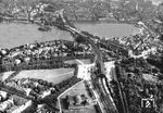 Luftaufnahme auf den Bahnhof Hamburg-Dammtor (Bildmitte) mit Alster, Lombardsbrücke und den Hauptbahnhof (ganz oben). Der Kuppelbau (unten) beherbergt die Universität. (1932) <i>Foto: Hansa-Luftbild</i>