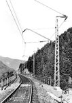 Seit der Eröffnung der Höllentalbahn stellte die Strecke durch Steigungen von bis zu 55 Promille die Eisenbahn vor extreme Herausforderungen. Um die Leistungsfähigkeit der Strecke zu erhöhen, entschloss sich die Reichsbahn im Jahr 1934 zur Elektrifizierung. Allerdings sollte dabei nicht die übliche Spannung von 15 kV, 16 2/3 Hz zur Anwendung kommen, sondern es wurde ein Versuchsbetrieb mit 20 kV und 50 Hz eingerichtet. Das Bild zeigt die neue Fahr- und Speiseleitung im Bereich der Ravennabrücke hinter dem Haltepunkt Höllsteig. (1934) <i>Foto: RVM</i>