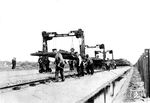 Die Deutsche Reichsbahn verwendete ab 1922 das S-49 Schienenprofil mit 49 kg/m, deren 15 m Schienenstücke sich gut mit einer solchen Hebeeinrichtung vom Wagen zum Einbauort transportieren ließen. (1930) <i>Foto: RVM</i>