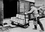 Im reinen Arbeiterdienst (also ohne Verbeamtung) waren die sog. Güterbodenarbeiter bei der Reichsbahn tätig. Sie hatten nicht nicht die Kisten zwischen Güterabfertigung und Wagen zu transportieren, sondern waren auch für die richtige und fachgemäße Ladung im Wagen verantwortlich, um Bruchschäden zu vermeiden. Das Bild entstand an der Güterabfertigung in Wuppertal-Oberbarmen. (1932) <i>Foto: RVM (Eckler)</i>