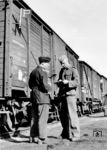 Übergabe eines Munitionszuges (gekennzeichnet mit der Pulverflagge - Signal Fz 3) vom "blauen" an den "grauen" Eisenbahner. Die im Wehrmachtstransportwesen eingesetzten zivilen Bediensteten der Deutschen Reichsbahn waren die sog. "blauen Eisenbahner", während die „Eisenbahntruppen” und „Feldeisenbahneinheiten” als sog. "graue Eisenbahner" Bestandteile des Heeres und damit der kämpfenden Truppe waren. Die Vorschriften für das Befördern sprenggefährlicher Gegenstände sahen 17 Einzelvorschriften vor, u.a. die Kennzeichnung mit Fz 3, besondere Anforderungen an die Wagen, Bewachung bei Unterwegsaufenthalten oder das vorbeifahrende Dampflokomotiven - möglichst auch beim Begegnen auf freier Strecke - Feuertür und Aschkastenklappen geschlossen zu halten haben. Das Bild wurde übrigens auch im Reichsbahn-Kalender von 1943 (Blatt 29) veröffentlicht. (1942) <i>Foto: RVM (Ittenbach)</i>