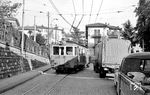 Die Lugano-Tesserete-Bahn (LT) italienisch: Ferrovia Lugano–Tesserete war neben der Lugano-Cadro-Dino-Bahn (LCD) und noch existierenden Lugano-Ponte-Tresa-Bahn (FLP) eine von ursprünglich drei von Lugano ausgehenden meterspurige Schmalspurbahnen. Eröffnet wurde sie 1909 und war von Beginn an elektrifiziert, die Einstellung erfolgte 1967. Ausgangspunkt der nur 8 km langen Bahn nach Tesserete war das eigene Stationsgebäude am Rande des Bahnhofsplatz der Gotthardbahn von Lugano. Charakteristisch für die Fahrzeuge waren ein Laternendach, das bei baugleichen Fahrzeugen in der Schweiz eher unüblich war. Wagen 2 (SIG, Baujahr 1909) zwängt sich von der Via Tesserete kommend auf dem Weg zum SBB-Bahnhof bei der Kreuzung mit der Via Massagno auf der Via San Gottardo durch Lugano. Beachtenswert ist auch die Oberleitungskreuzung von Bahn und O-Bus. (16.10.1964) <i>Foto: Gerd Wolff</i>